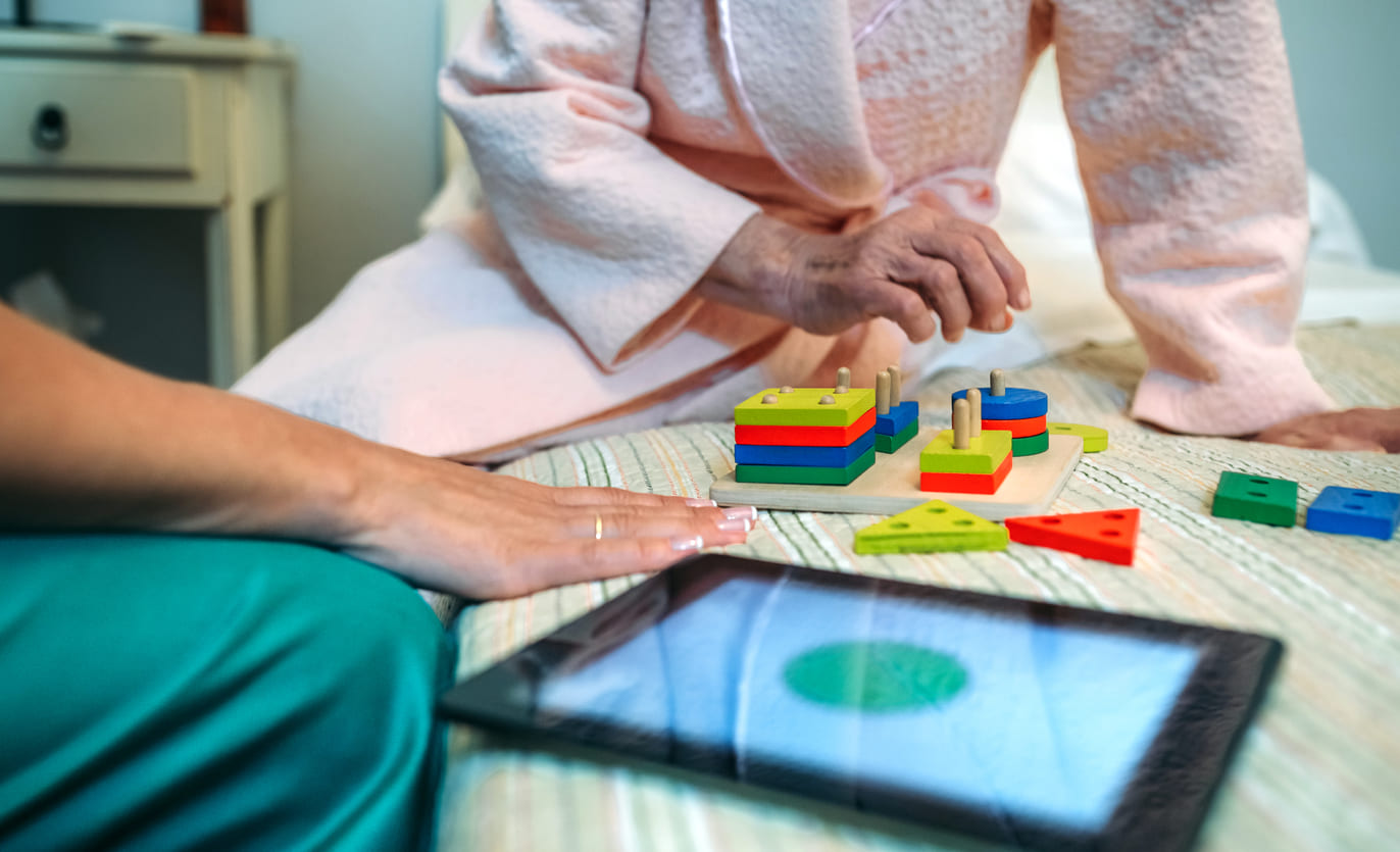 female-doctor-showing-geometric-shapes-to-elderly-2025-03-13-23-17-17-utc